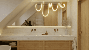 Miedziane baterie i minimalistyczne lustro z podświetleniem LED w jasnej łazience